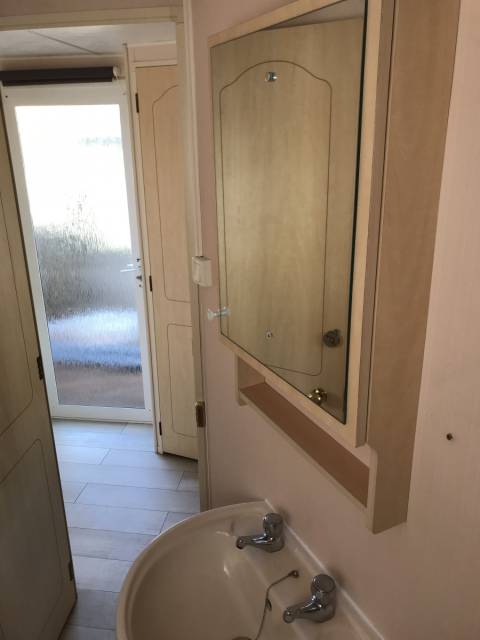 L'évier et le miroir de la salle de bain du Mobil home d’occasion Atlas Everglade 2002