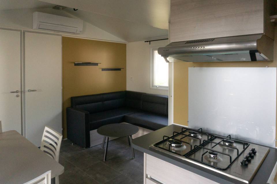 Pièce à vivre du mobil home neuf 2 chambres TRIGANO Evo 29 sur parcelle en camping
