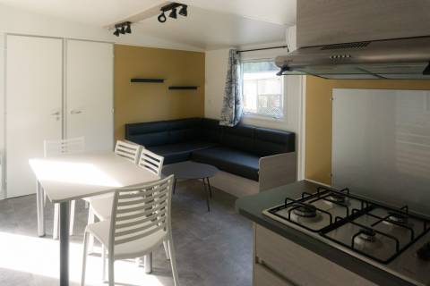 Pièce à vivre du mobil home neuf 2 chambres TRIGANO Evo 33 sur sa parcelle en camping