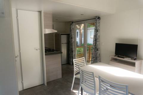 Pièce à vivre du mobil home neuf 2 chambres TRIGANO Evo 33 sur sa parcelle en camping