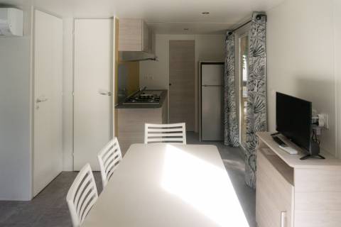 Pièce à vivre du mobil home neuf 2 chambres TRIGANO Evo 33 sur sa parcelle en camping